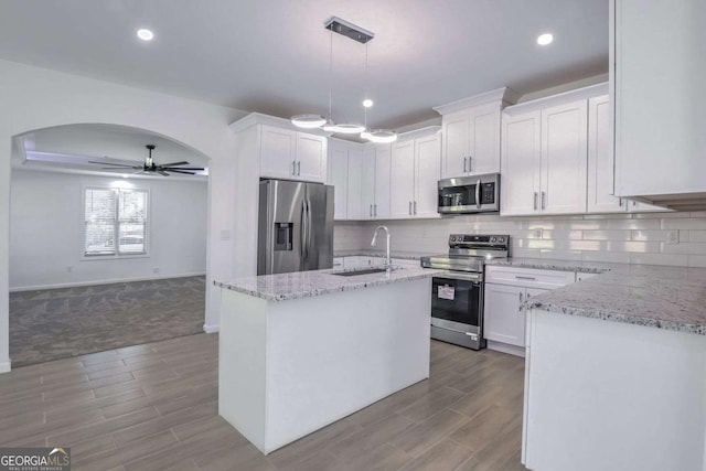 4066 Wild Orchid Ln, Loganville, GA 30052 - kitchen featuring a sink, appliances with stainless steel finishes, a ceiling fan, white cabinetry, and light stone countertops