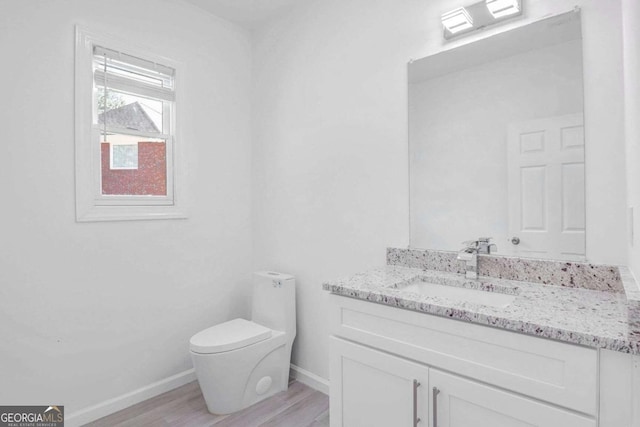 4066 Wild Orchid Ln, Loganville, GA 30052 - half bathroom with vanity, baseboards, toilet, and wood finished floors