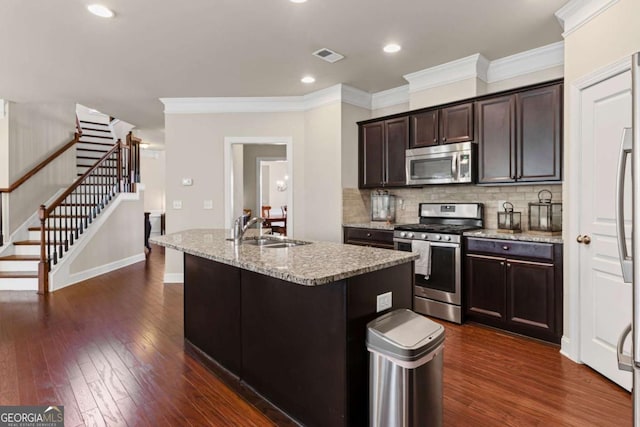 kitchen with dark wood-type flooring, a sink, visible vents, and stainless steel appliances