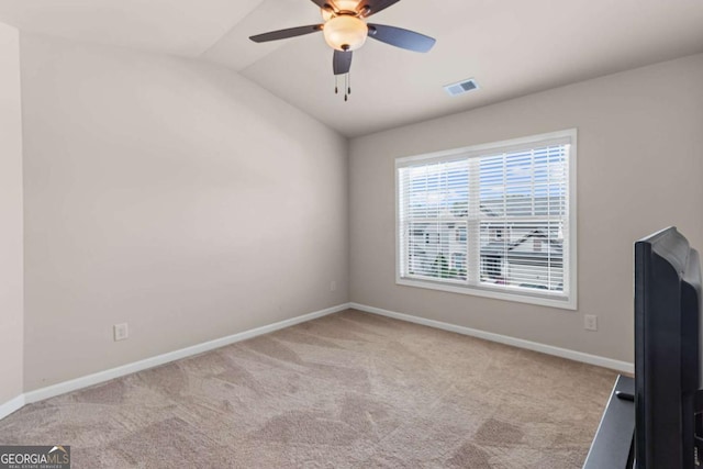 empty room featuring carpet flooring, baseboards, a ceiling fan, and lofted ceiling