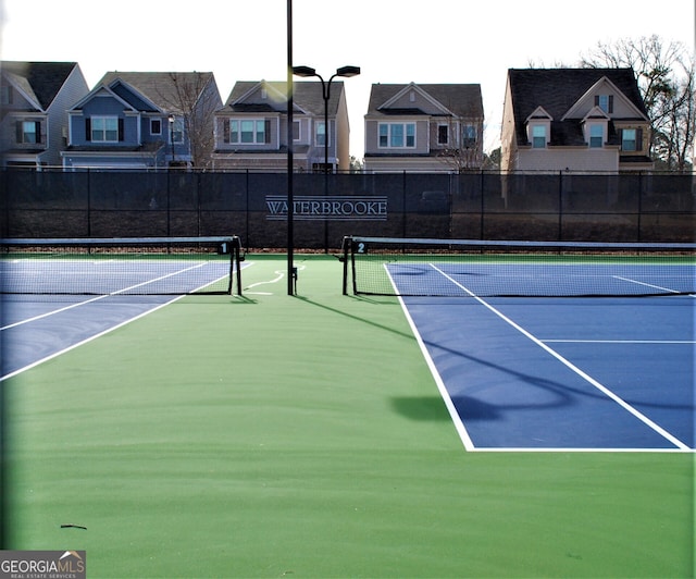 view of sport court with community basketball court, fence, and a residential view