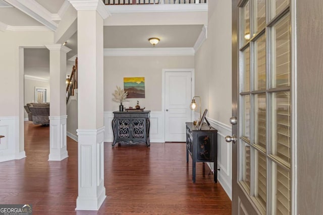 foyer featuring ornate columns, dark wood-style flooring, and ornamental molding