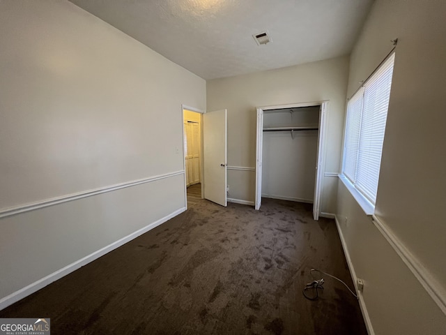 7560 Taylor Rd # 5, Riverdale, GA 30274 - unfurnished bedroom featuring visible vents, baseboards, carpet flooring, and a closet