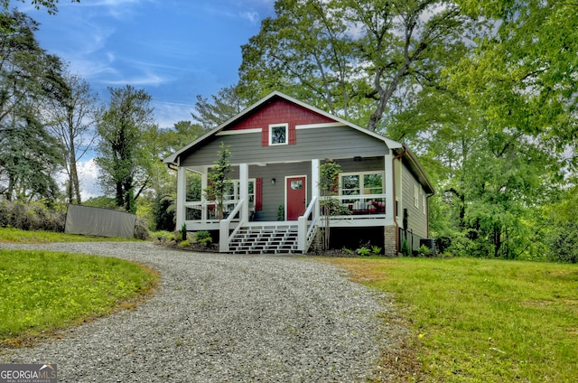 bungalow-style home featuring stairway, covered porch, and driveway