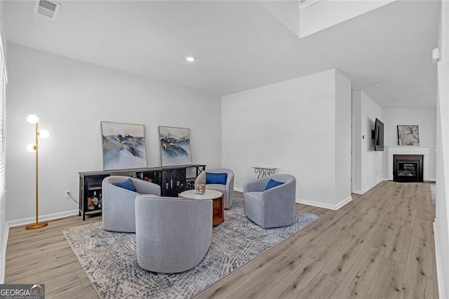 living room featuring visible vents, wood finished floors, and a healthy amount of sunlight