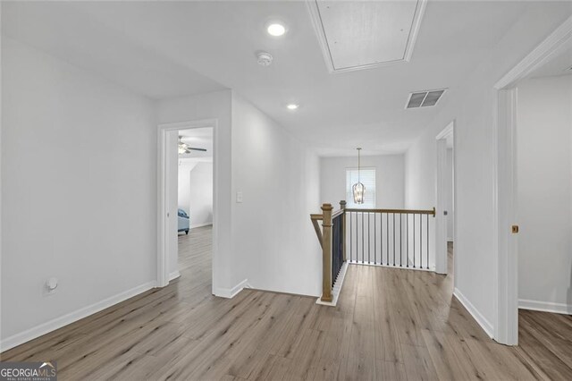 bedroom featuring light wood finished floors, baseboards, a ceiling fan, and a tray ceiling