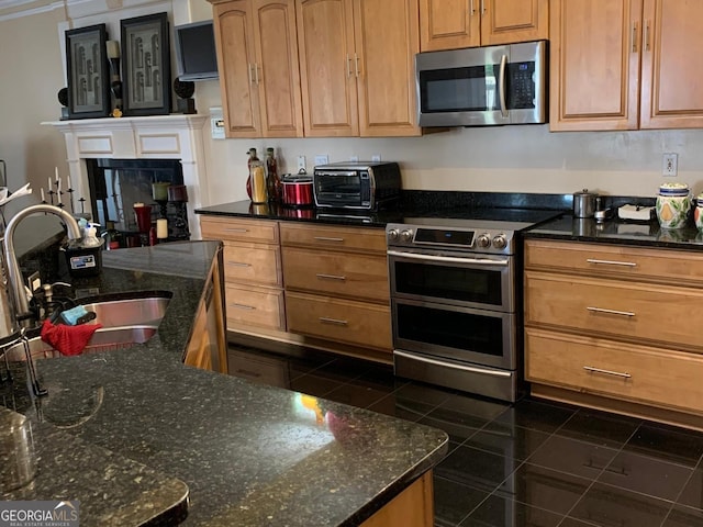 6279 Giles Rd, Lithonia, GA 30058 - kitchen with stainless steel appliances, dark stone counters, and brown cabinets