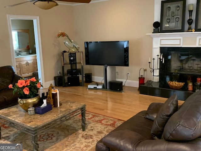 6279 Giles Rd, Lithonia, GA 30058 - living area with wood finished floors, a ceiling fan, a glass covered fireplace, and ornamental molding