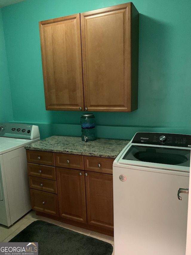 6279 Giles Rd, Lithonia, GA 30058 - laundry area featuring cabinet space, light tile patterned floors, and separate washer and dryer