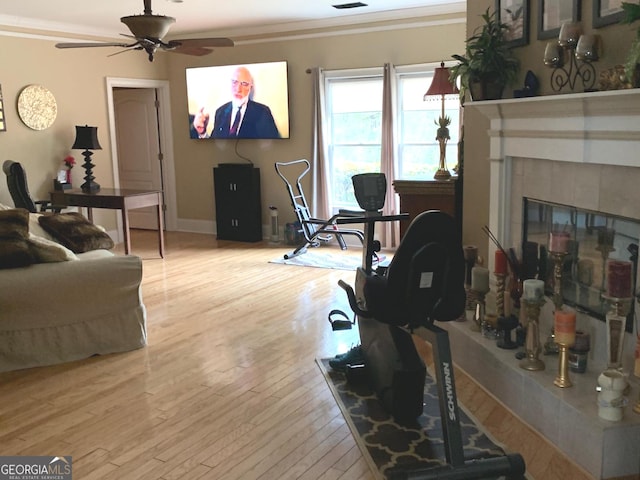 6279 Giles Rd, Lithonia, GA 30058 - living room featuring ceiling fan, hardwood / wood-style floors, crown molding, and a tiled fireplace