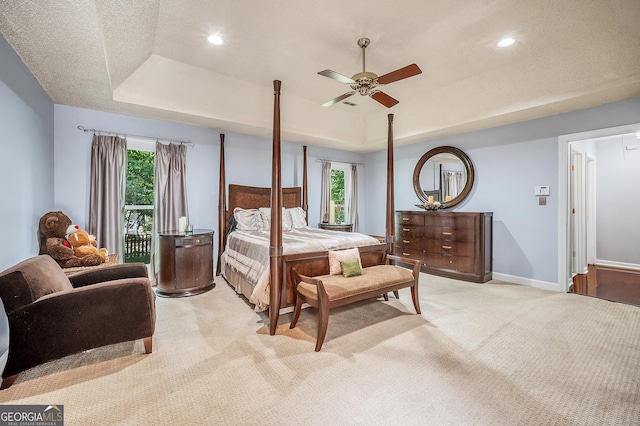 bedroom featuring light colored carpet, recessed lighting, a ceiling fan, baseboards, and a tray ceiling