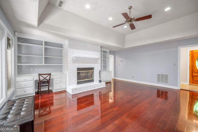 unfurnished living room featuring a ceiling fan, baseboards, visible vents, and wood finished floors