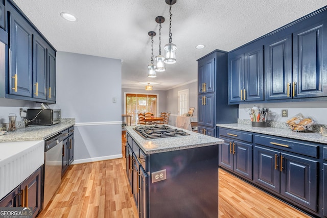 kitchen featuring a kitchen island, blue cabinets, a textured ceiling, appliances with stainless steel finishes, and light wood-type flooring