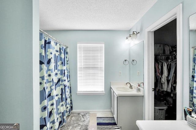 321 Harris Ave, Locust Grove, GA 30248 - full bath with vanity, a textured ceiling, a spacious closet, curtained shower, and baseboards