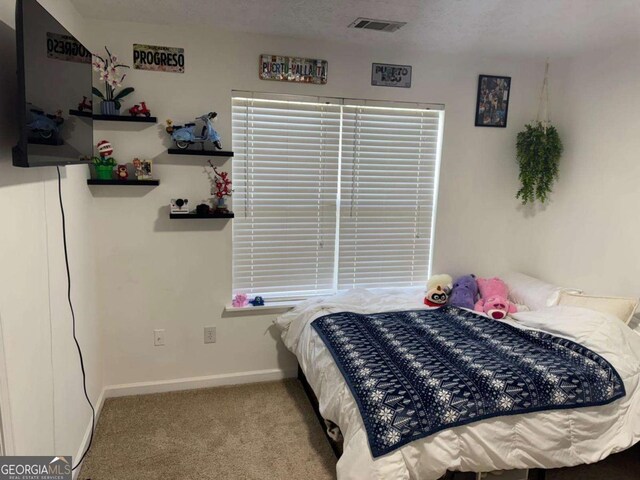 bedroom with visible vents, baseboards, and carpet