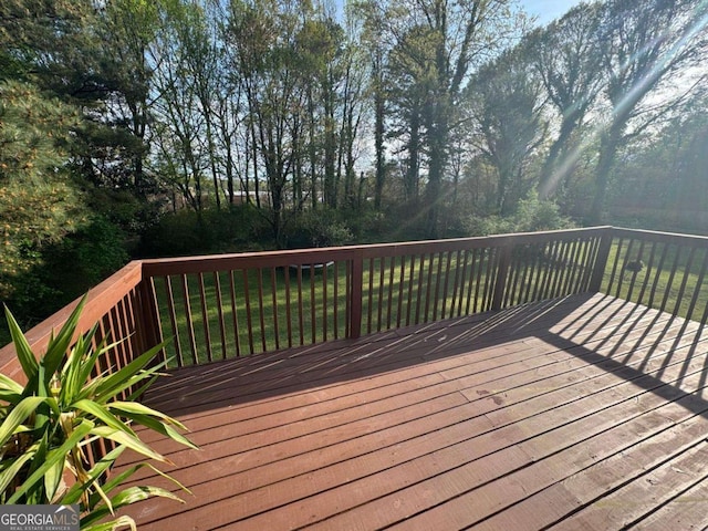 wooden terrace featuring a lawn