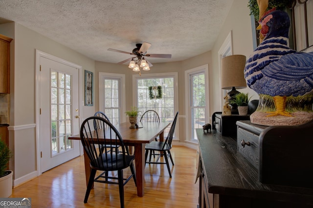dining room with light wood finished floors, a ceiling fan, and a wealth of natural light