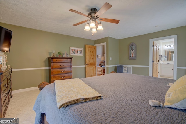 carpeted bedroom featuring ensuite bathroom, baseboards, a ceiling fan, and a textured ceiling