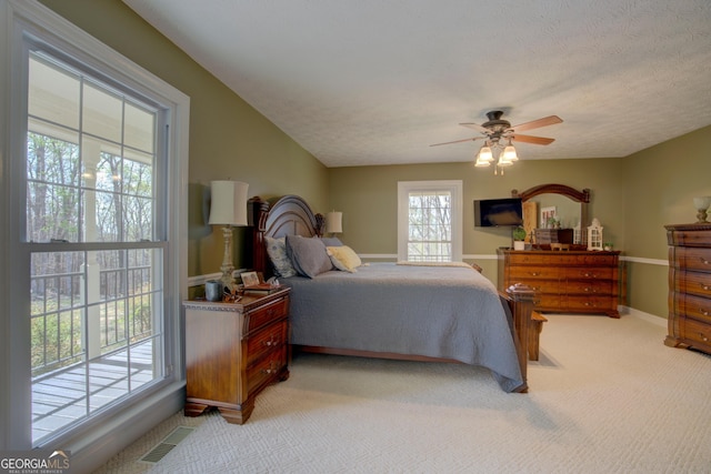 bedroom featuring light carpet, baseboards, visible vents, and a textured ceiling
