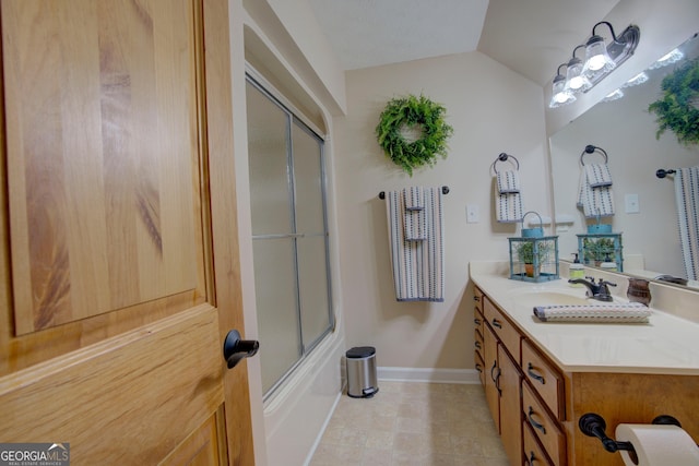 bathroom featuring baseboards, vanity, vaulted ceiling, and shower / bath combination with glass door
