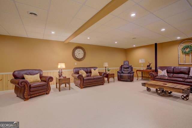 living room with a drop ceiling, wainscoting, visible vents, and carpet floors