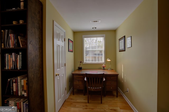 home office with visible vents, baseboards, and light wood-style flooring