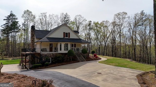 view of front of property featuring a porch, a front yard, stairs, a chimney, and driveway