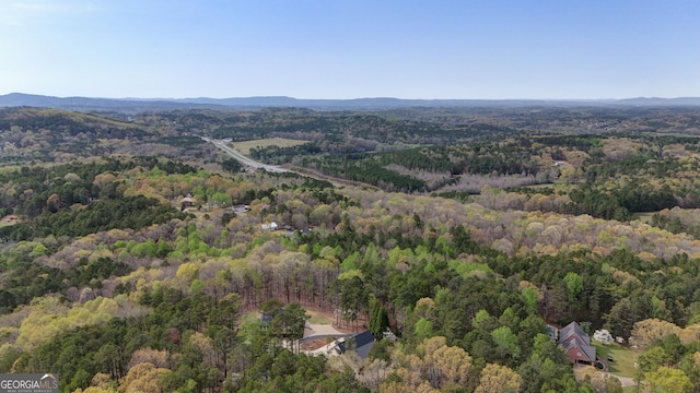 birds eye view of property featuring a wooded view and a mountain view