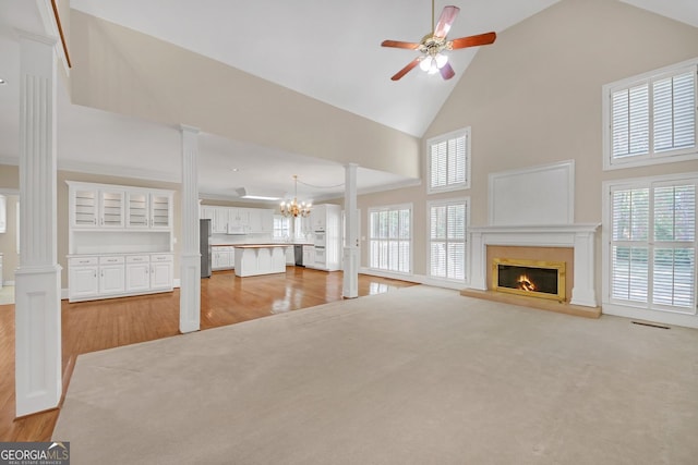 1405 Wilmington Way, Grayson, GA 30017 - unfurnished living room with ornate columns, a glass covered fireplace, light wood-style floors, and high vaulted ceiling