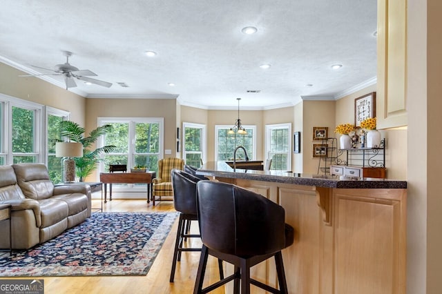 interior space with recessed lighting, light wood-type flooring, ornamental molding, and hanging light fixtures