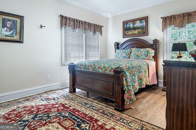 bedroom with crown molding, baseboards, and wood finished floors