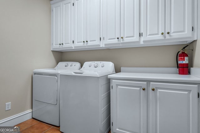 washroom featuring tile patterned flooring, cabinet space, and washer and clothes dryer