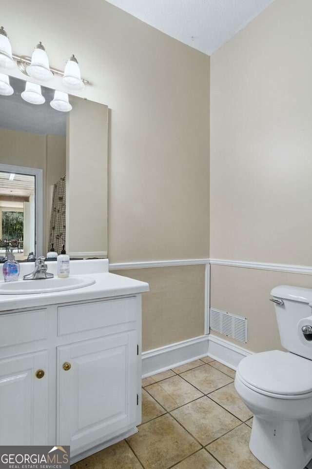 bathroom featuring toilet, vanity, tile patterned flooring, and visible vents