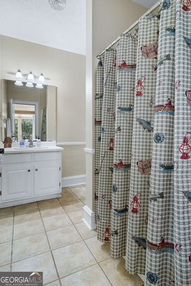 full bathroom with tile patterned floors, a shower with curtain, vanity, and baseboards