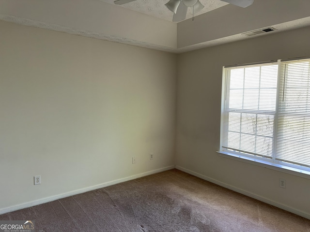 unfurnished room featuring visible vents, ceiling fan, carpet flooring, and a wealth of natural light