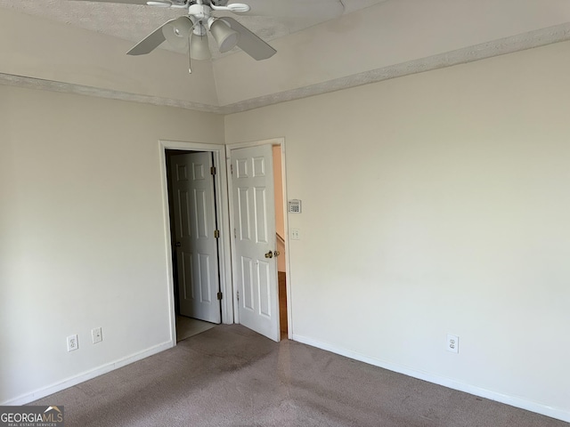 carpeted empty room with ceiling fan and baseboards