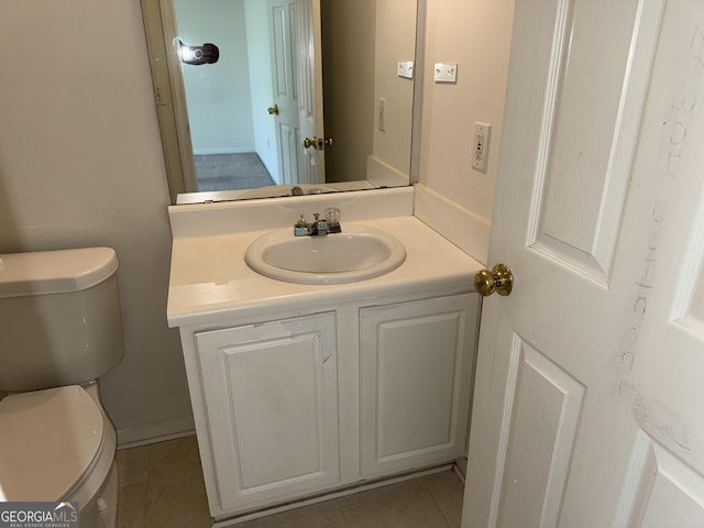 half bathroom with toilet, tile patterned floors, and vanity