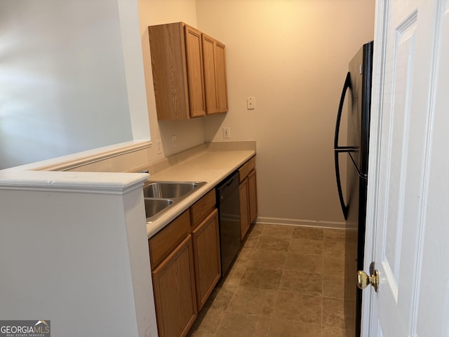 kitchen with baseboards, a peninsula, light countertops, brown cabinetry, and black appliances