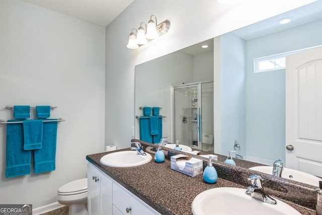 bathroom featuring a sink, toilet, double vanity, and a stall shower