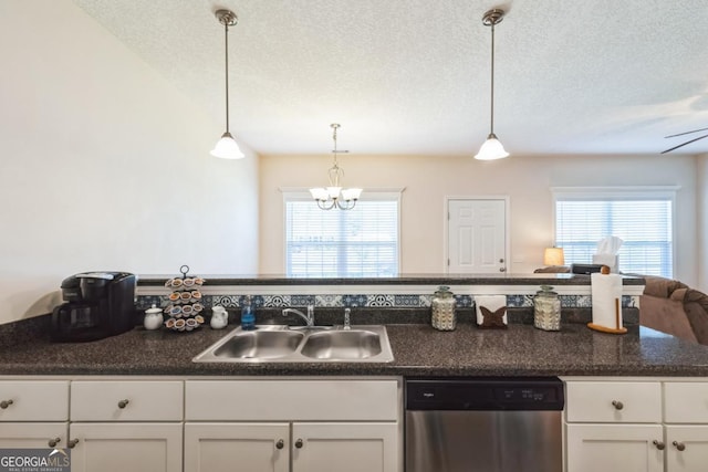 kitchen with a textured ceiling, white cabinets, dishwasher, a sink, and dark countertops