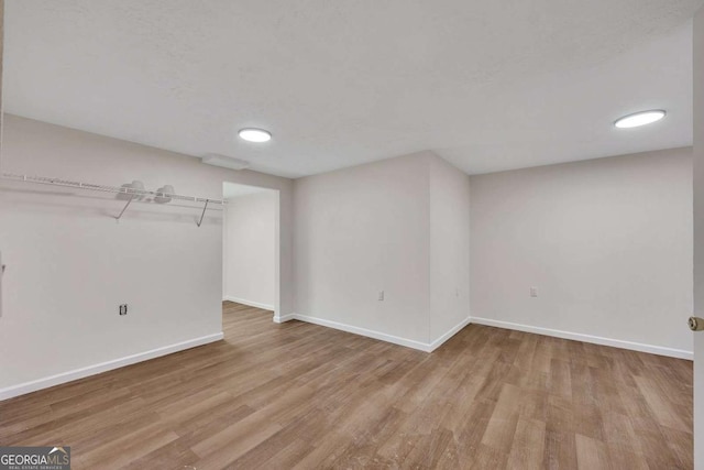 basement with baseboards and wood finished floors