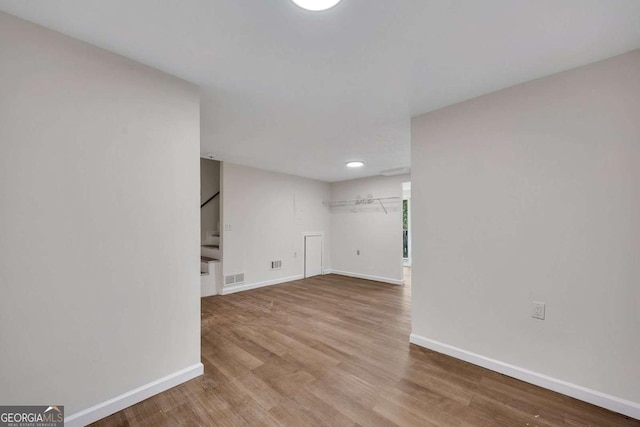 finished below grade area with visible vents, baseboards, and wood finished floors
