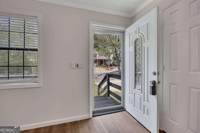 entrance foyer featuring ornamental molding, baseboards, plenty of natural light, and wood finished floors