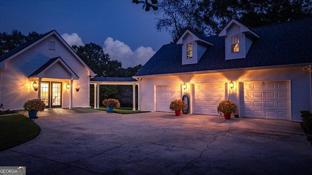 view of front of property with french doors, concrete driveway, and a garage