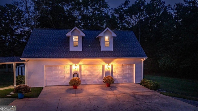 view of front of house with an outbuilding, a detached garage, and roof with shingles