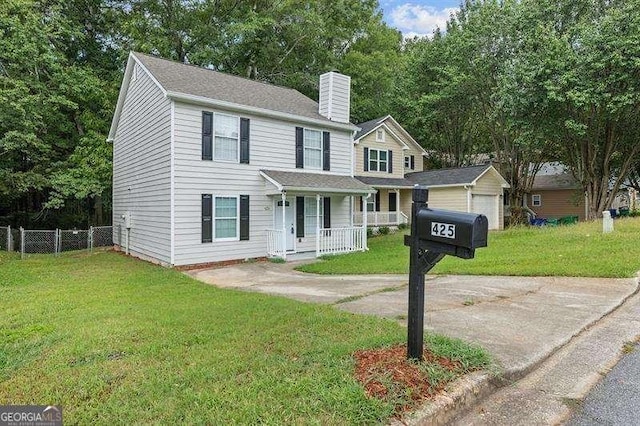view of front of home featuring fence, a front yard, a chimney, and covered porch