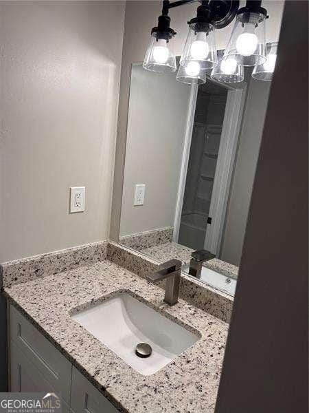 bathroom with an inviting chandelier and vanity