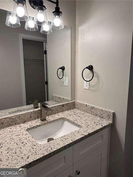 bathroom with a chandelier and vanity