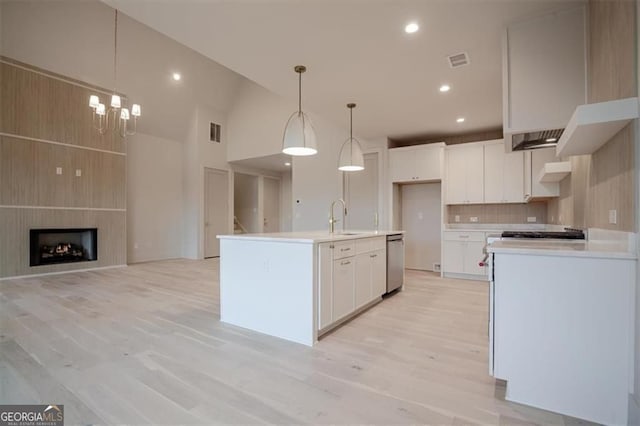 310 Arbor Garden Cir, Newnan, GA 30265 - kitchen featuring a sink, light countertops, white cabinetry, decorative backsplash, and decorative light fixtures
