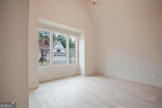 310 Arbor Garden Cir, Newnan, GA 30265 - empty room with light wood-type flooring, a chandelier, and high vaulted ceiling